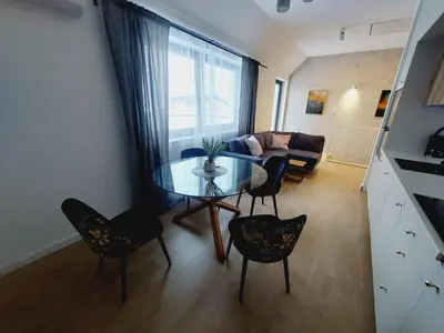a living room with a glass table and chairs at Komfortowe mieszkanie, duży taras, bezpłatny parking, AWG APARTMENTS in Kraków