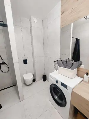 a white bathroom with a toilet and a sink at Komfortowe mieszkanie, duży taras, bezpłatny parking, AWG APARTMENTS in Kraków