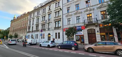 a busy city street with cars parked in front of buildings at Pawia Apartments Centrum in Kraków