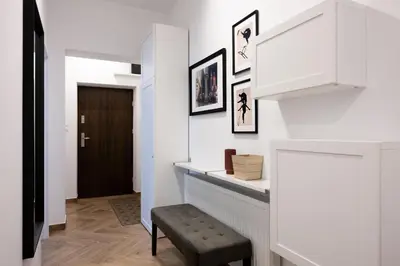 a hallway with white walls and a black door at Native Apartments Pułaskiego 6 in Kraków