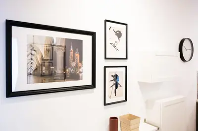a group of framed pictures hanging on a wall at Native Apartments Pułaskiego 6 in Kraków