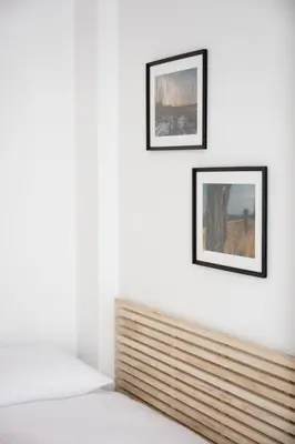 a bedroom with two framed pictures on the wall at Native Apartments Pułaskiego 6 in Kraków