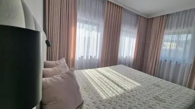 a bedroom with a bed with white sheets and windows at Piotruś Pan in Brzesko