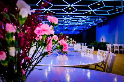 a table with pink flowers on it with white chairs at Piotruś Pan in Brzesko