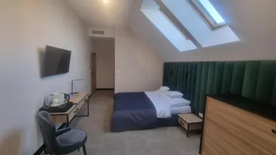 a bedroom with a bed and a desk and a television at Piotruś Pan in Brzesko