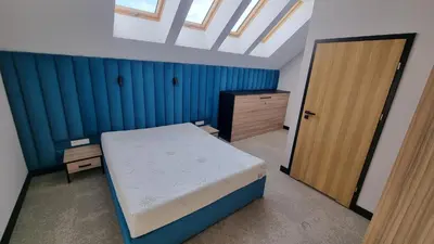 a bedroom with a bed and a wooden door at Piotruś Pan in Brzesko
