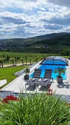 a swimming pool with two lounge chairs next to it at Owocowe Wzgórze in Tęgoborze