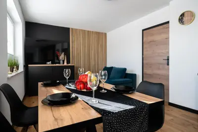 a dining room with a table with wine glasses at Owocowe Wzgórze in Tęgoborze