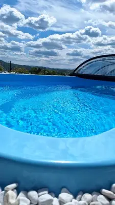 a pool of water with a bridge in the background at Owocowe Wzgórze in Tęgoborze