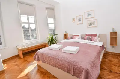 a bedroom with a large bed with two towels on it at Sunny Corner in Kraków