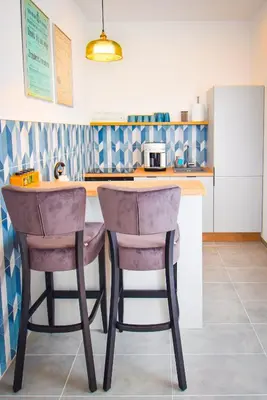a kitchen with two bar stools in front of a counter at Sunny Corner in Kraków