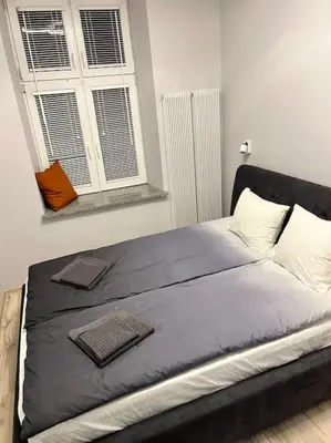 a large bed in a bedroom with a window at V&O Apartament in the centre of Krakow in Kraków