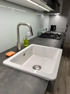 a white sink in a kitchen with a stove at V&O Apartament in the centre of Krakow in Kraków