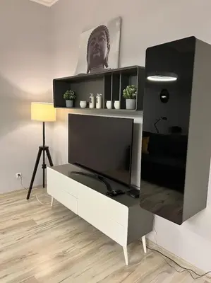 a entertainment center with a large television in a living room at V&O Apartament in the centre of Krakow in Kraków