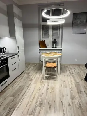 a kitchen with wooden floors and a table in it at V&O Apartament in the centre of Krakow in Kraków