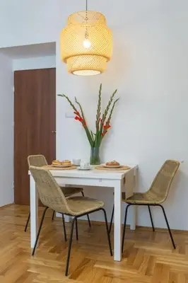 a white table with chairs and a vase with flowers at June B studio in Kraków
