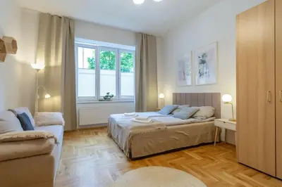 a bedroom with a bed and a couch and a window at June B studio in Kraków