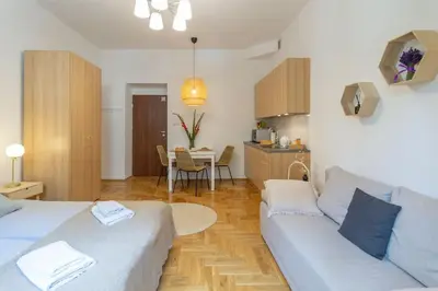 a living room with a couch and a kitchen at June B studio in Kraków