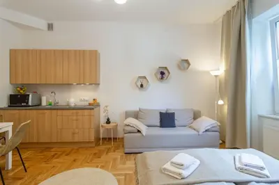 a living room with a couch and a kitchen at June B studio in Kraków