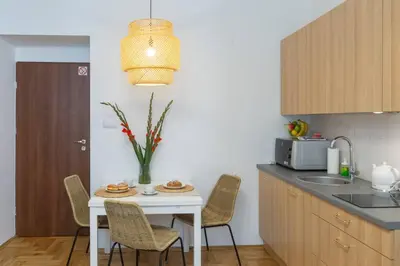 a kitchen with a white table with chairs and a table at June B studio in Kraków