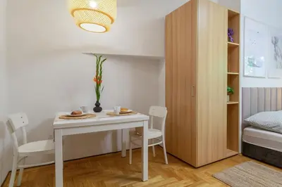 a small room with a table and chairs and a bed at June C studio w/small balcony in Kraków
