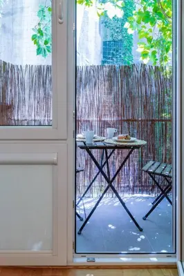 a table and chairs on a patio outside a window at June C studio w/small balcony in Kraków