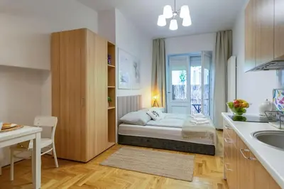 a room with a bed in a kitchen with a sink at June C studio w/small balcony in Kraków