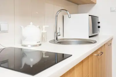 a kitchen counter with a sink and a microwave at June C studio w/small balcony in Kraków