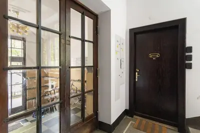 a wooden door in a room with a window at June C studio w/small balcony in Kraków