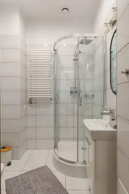 a white bathroom with a shower and a sink at June C studio w/small balcony in Kraków