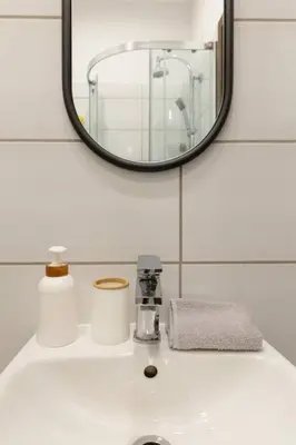 a bathroom sink with a mirror and a towel at May A studio in Kraków