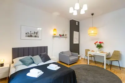a bedroom with a bed and a desk and a chair at May B studio in Kraków