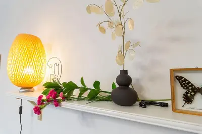 a shelf with a vase and flowers on it at May B studio in Kraków