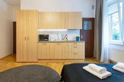 a kitchen with wooden cabinets and a microwave at May B studio in Kraków