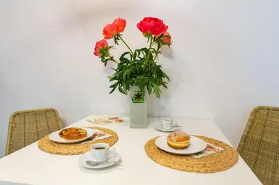 a table with two plates and a vase of flowers at May B studio in Kraków