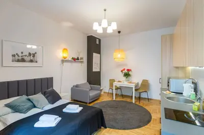 a bedroom with a bed and a kitchen with a sink at May B studio in Kraków