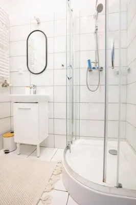 a white bathroom with a shower and a sink at May B studio in Kraków