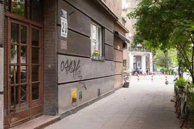 a building with graffiti on the side of a street at May C studio w/balcony in Kraków