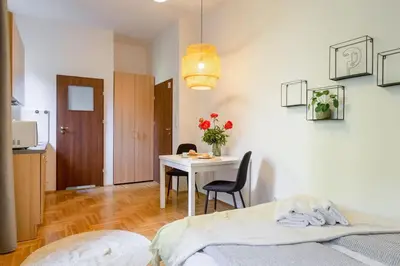 a bedroom with a table and a bed and a table and chairs at May C studio w/balcony in Kraków