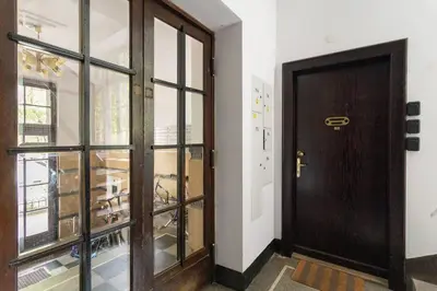 a wooden door in a room with a window at May C studio w/balcony in Kraków