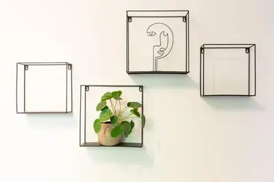 four frames with a plant in a vase on a wall at May C studio w/balcony in Kraków