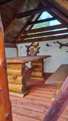 an inside of a cabin with a table and a window at Pieśń Poranka Domek in Łysina