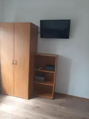 a wooden cabinet with a television on a wall at Apartamenty Marco 3-Bis- Przy Dworcu-Stare Miasto-Super Wi Fi in Kraków