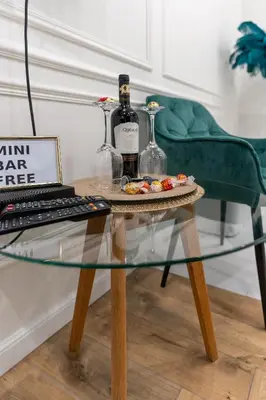 a glass table with two bottles of wine and a keyboard at Apartament z Jacuzzi Kraków SHADOW Zamoyskiego in Kraków