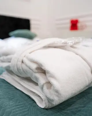 a pile of white towels sitting on top of a bed at Apartament z Jacuzzi Kraków SHADOW Zamoyskiego in Kraków