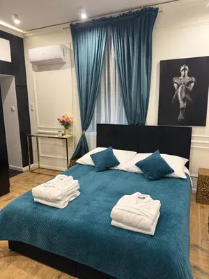 a bedroom with a blue bed with towels on it at Apartament z Jacuzzi Kraków SHADOW Zamoyskiego in Kraków