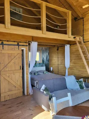 a living room with a bed and a loft at Dream Catcher House - dom do wynajęcia w górach in Limanowa