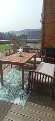 a wooden picnic table and two benches on a deck at Dream Catcher House - dom do wynajęcia w górach in Limanowa