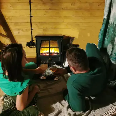 a group of people sitting around a table in front of a fireplace at Dream Catcher House - dom do wynajęcia w górach in Limanowa