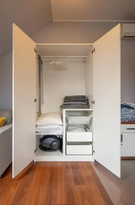 a walk in closet with white walls and wooden floors at A comfortable apartment midway Kraków-Oświęcim in Chrzanów